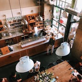 A vibrant aerial view of a busy cafe in Kraków, showcasing patrons enjoying baked goods and coffee.